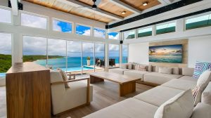 Anguilla luxury villa perched above Crocus Bay with spacious living room, large windows, and private pool overlooking the ocean.