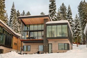 Northstar luxury mountain home covered in snow, featuring modern and elegant exterior with large windows and scenic mountain views.