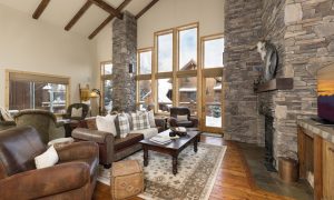 Big Sky ski-in:ski-out lodge living space with rustic wood beams, cozy seating, and mountain views