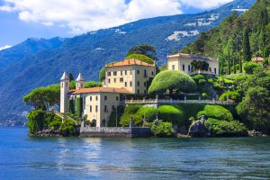 A grand house situated on a hill, offering a picturesque view of Lake Como and the surrounding landscape.