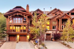 Exterior view of the renovated Deer Valley residence surrounded by lush greenery and mountain scenery in Park City, Utah.