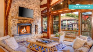 Open-concept living area inside renovated Deer Valley residence featuring stone fireplace and wood-beamed ceilings.
