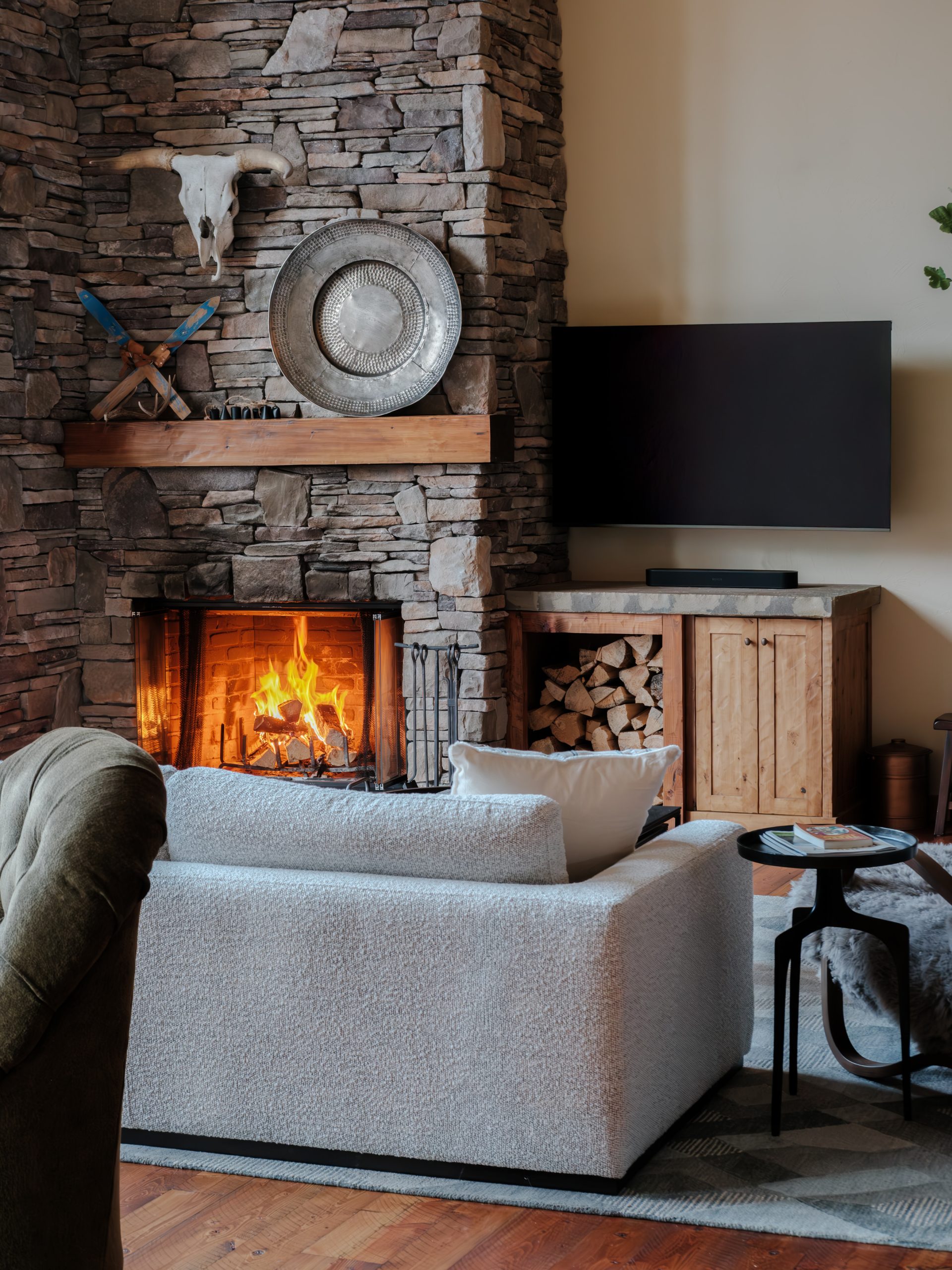 Montana luxury mountain home living room centered around stone fireplace.
