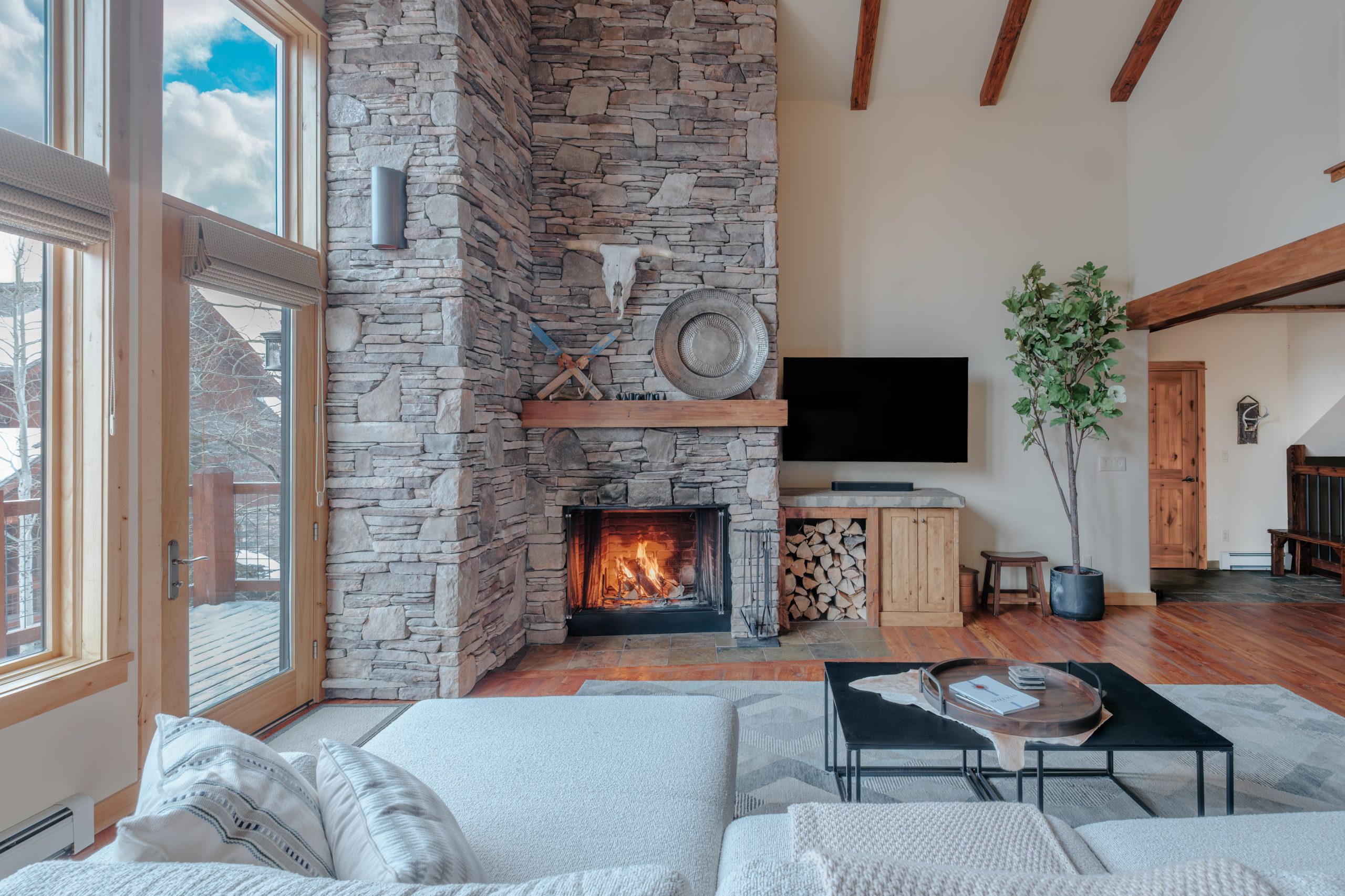 Luxury living room with stone fireplace and vaulted ceilings in Big Sky Montana.