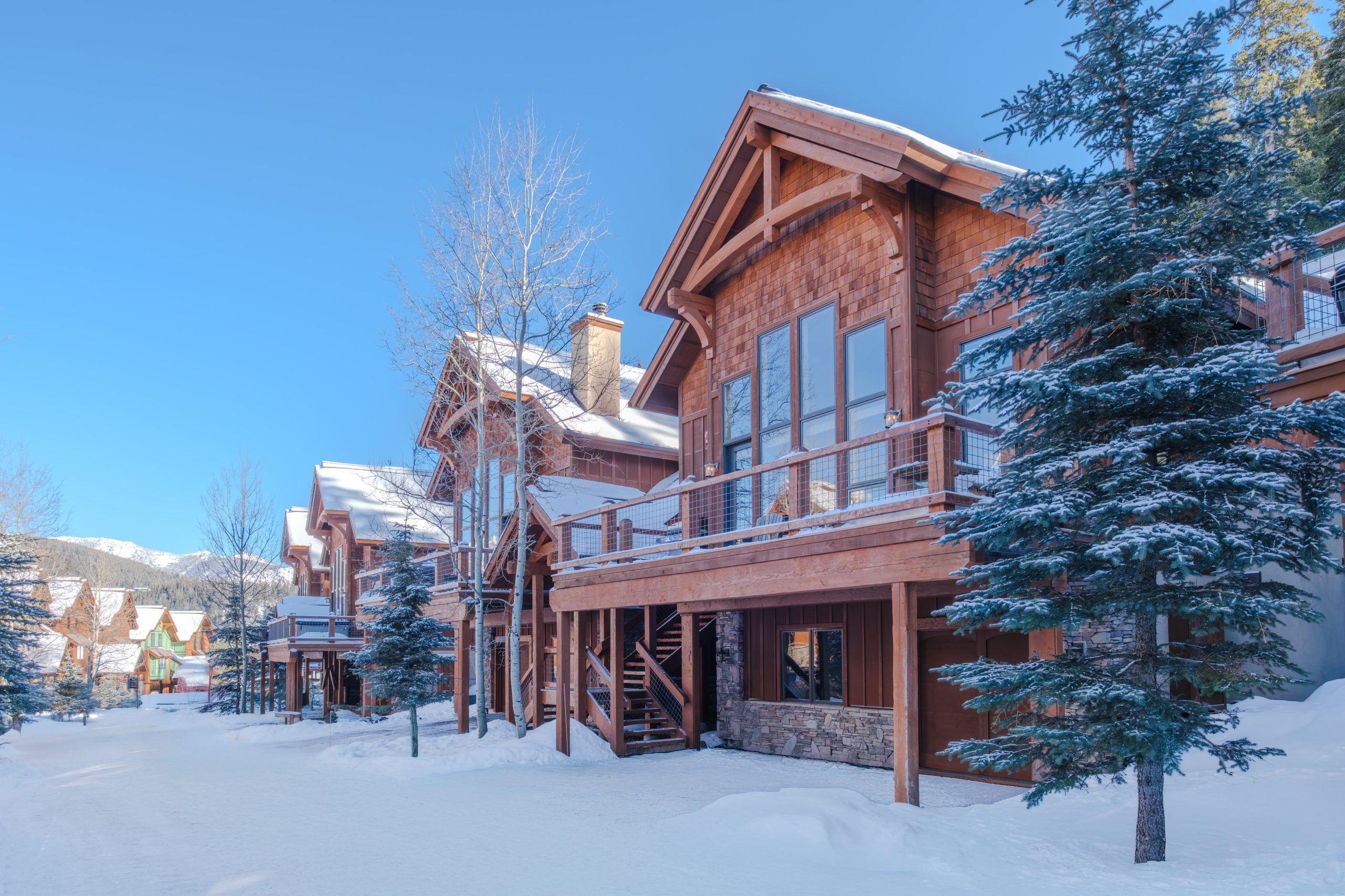Luxury Big Sky Montana estate nestled among tall pines and snowy mountains.