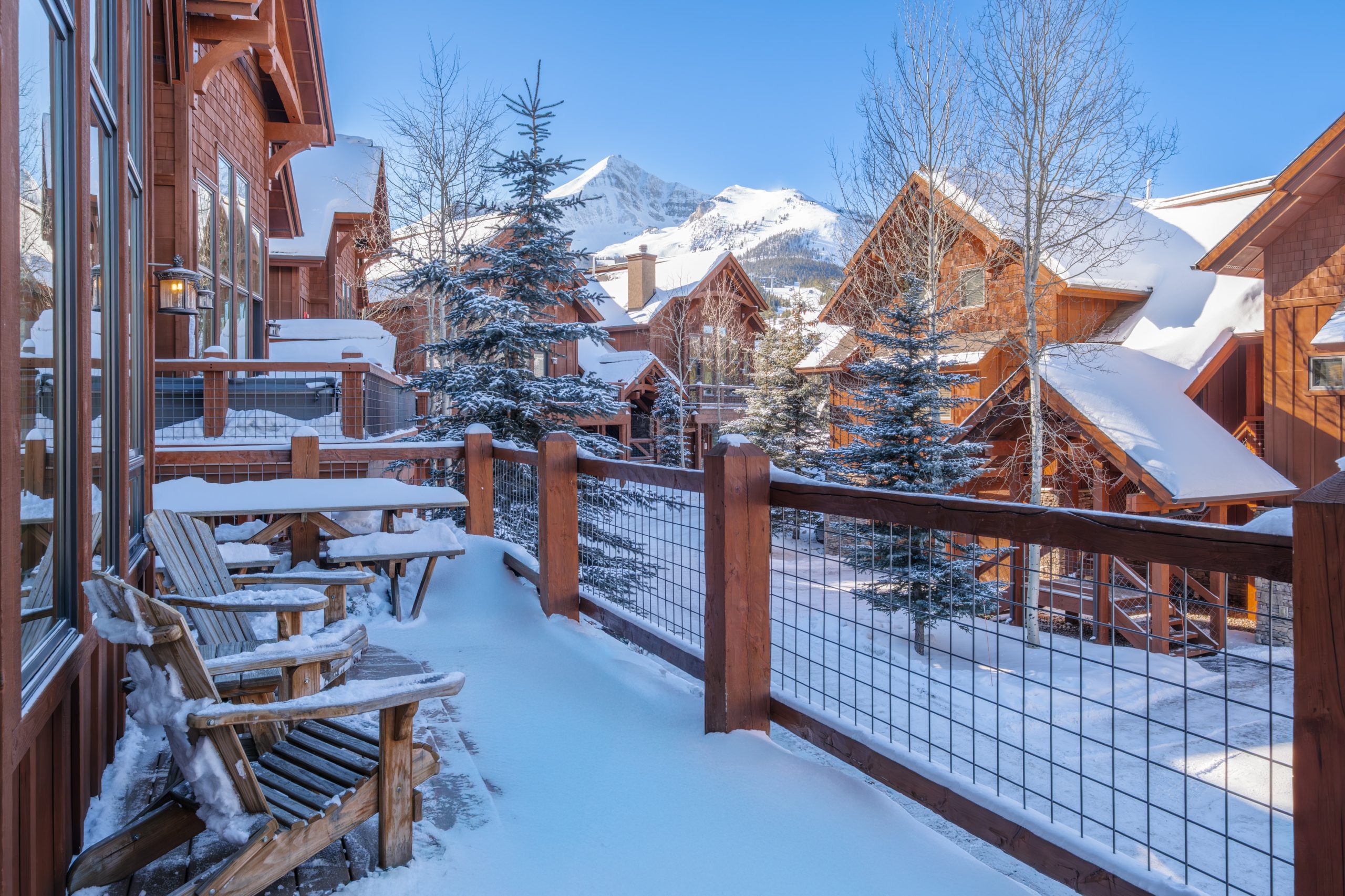 Luxury Big Sky Montana estate nestled among tall pines and snowy mountains.