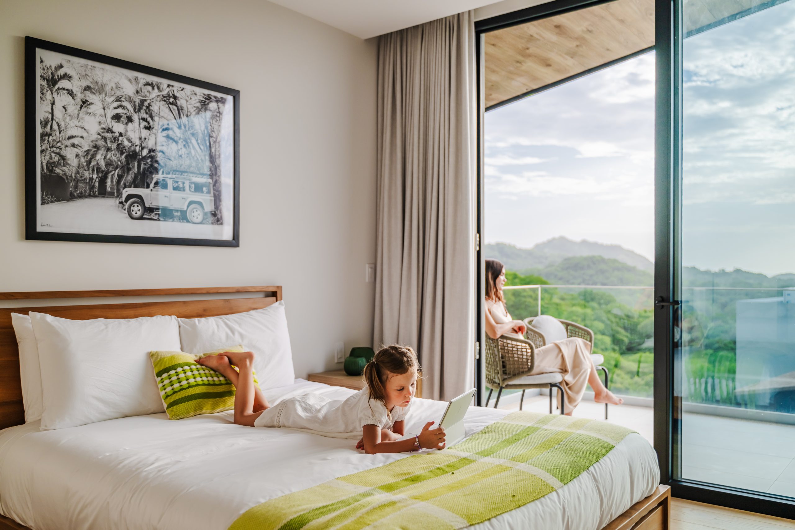 A Cute Girl Enjoying in her Spacious Bedroom with a Terrace Overlooking the Pacific Ocean at Solaris Reserva Conchal Penthouse in Costa Rica