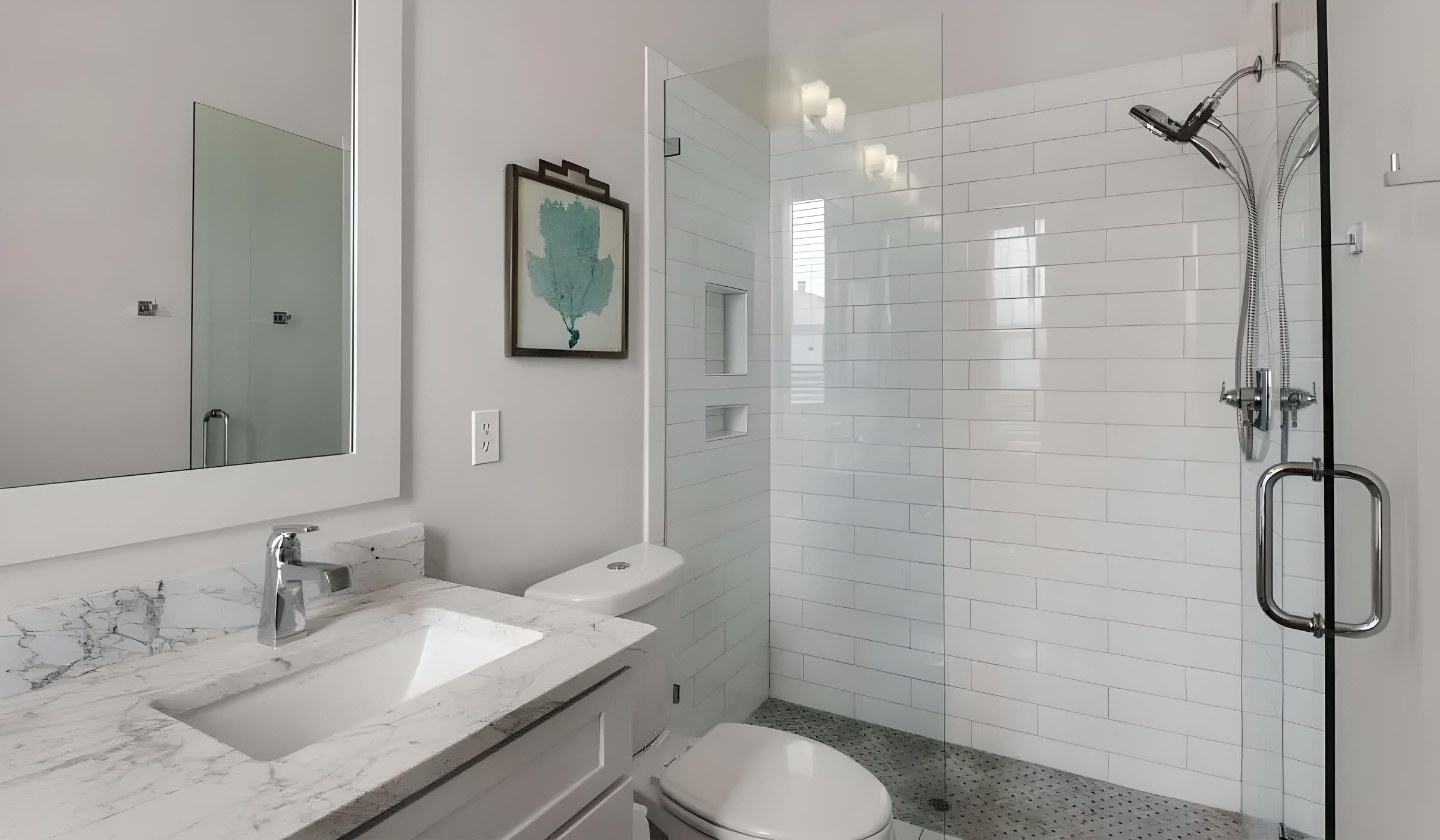 Modern bathroom with marble countertop, sleek faucet, glass shower enclosure, and decorative wall art, showcasing luxury features in a renovated Seacrest Beach home.