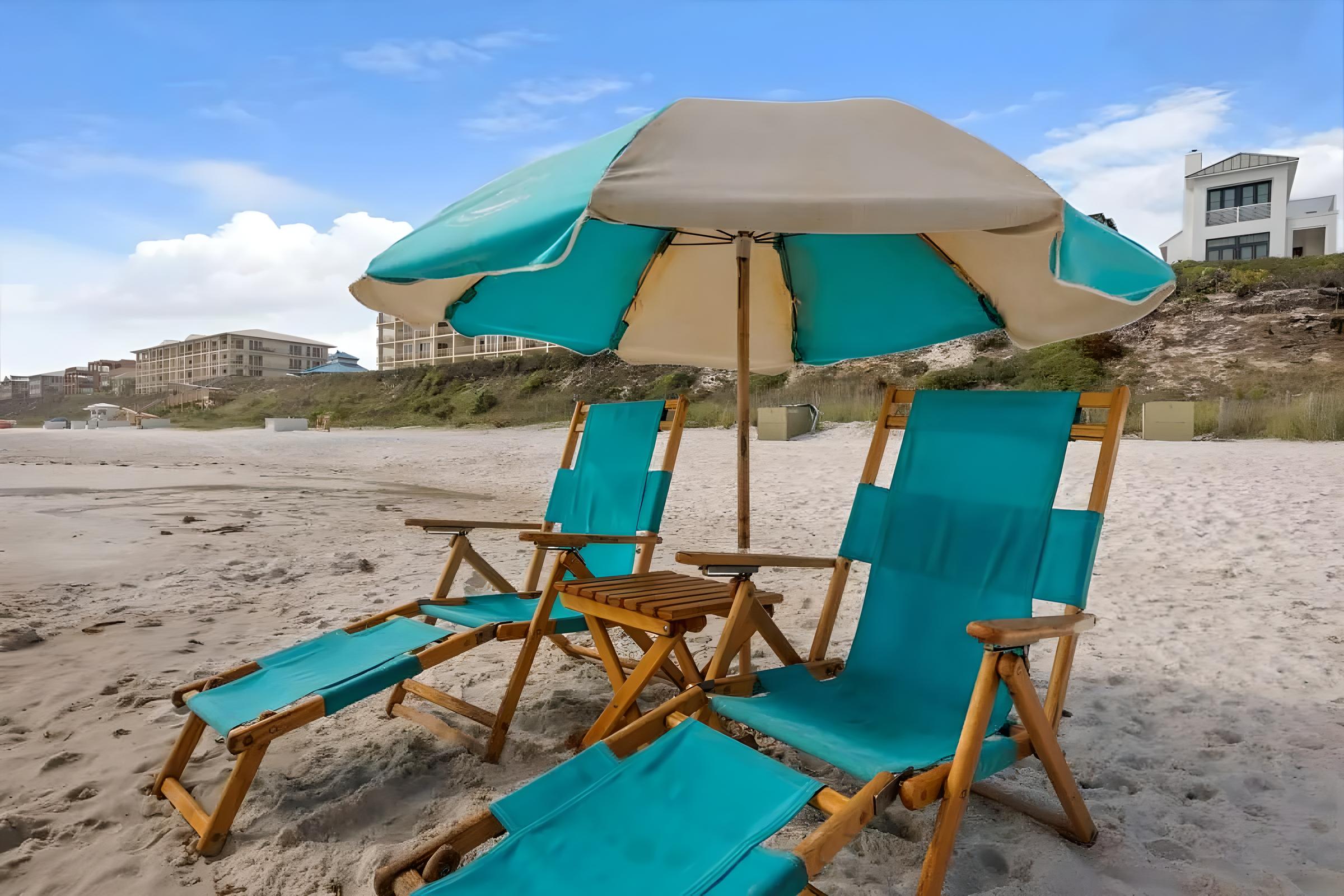 Beach chairs and umbrella on sandy shore near luxury Seacrest Beach home, ideal for family vacations and relaxation on Florida's Emerald Coast.
