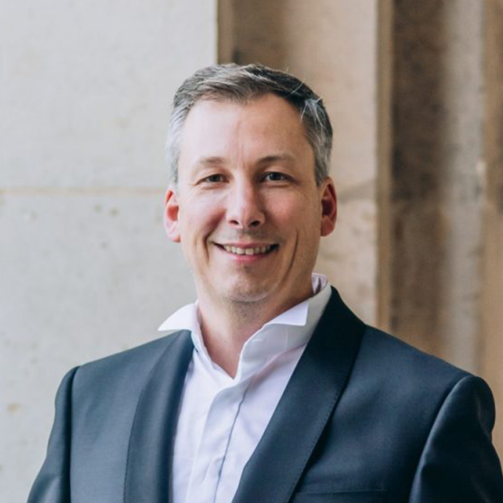 Greg Salley in a suit smiling, representing Equity Residences' team expertise in luxury real estate investment.