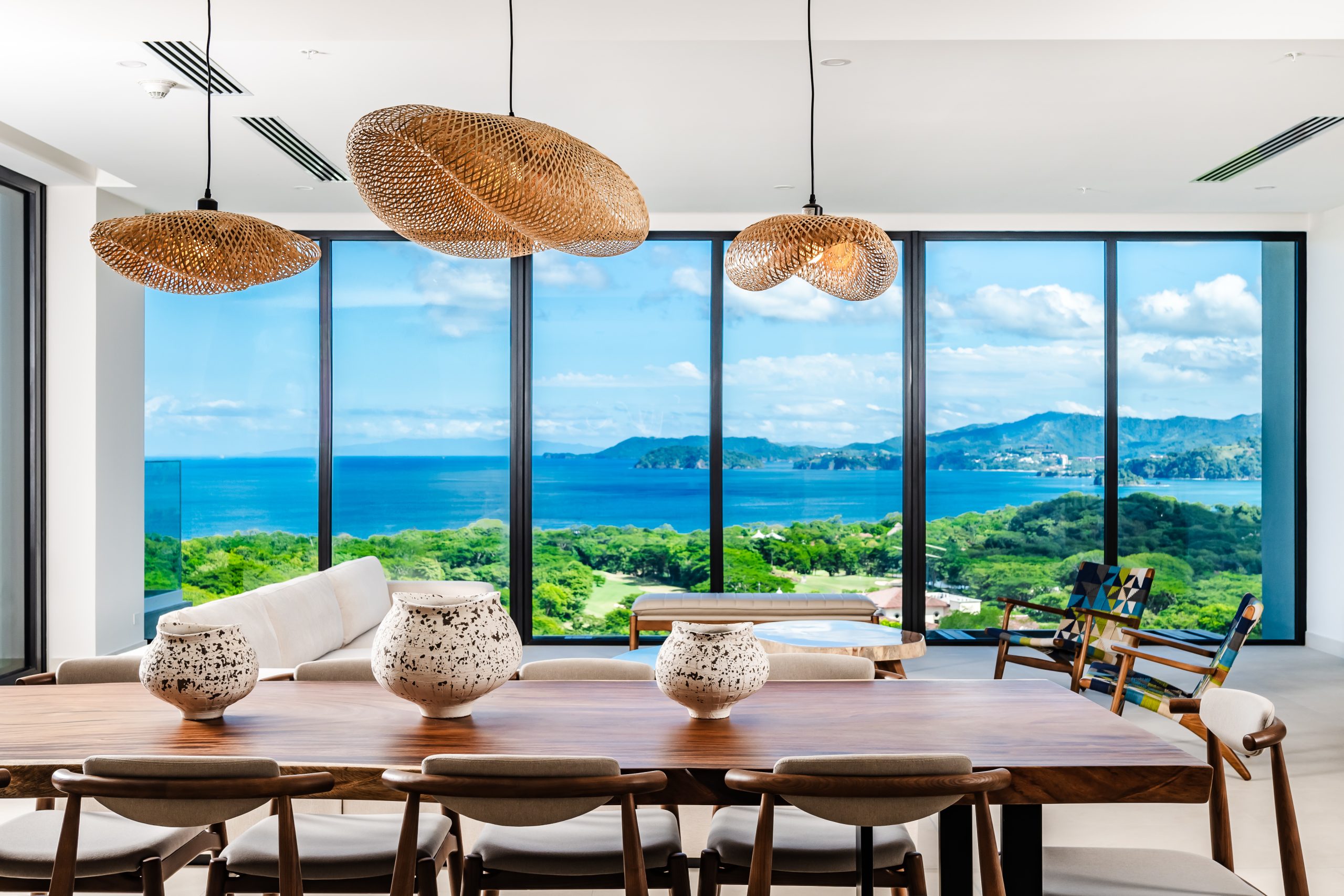Luxury Tropical Vibe Wooden Dining Table with Elegant Rattan Chandelier at Solaris Reserva Conchal Penthouse With Ocean Views