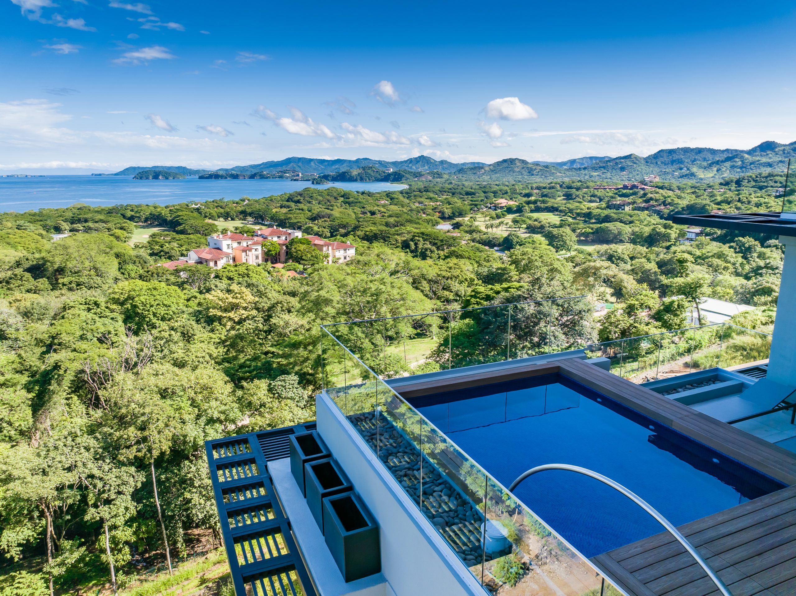 Ocean-view pool surrounded by tropical greenery at Reserva Conchal