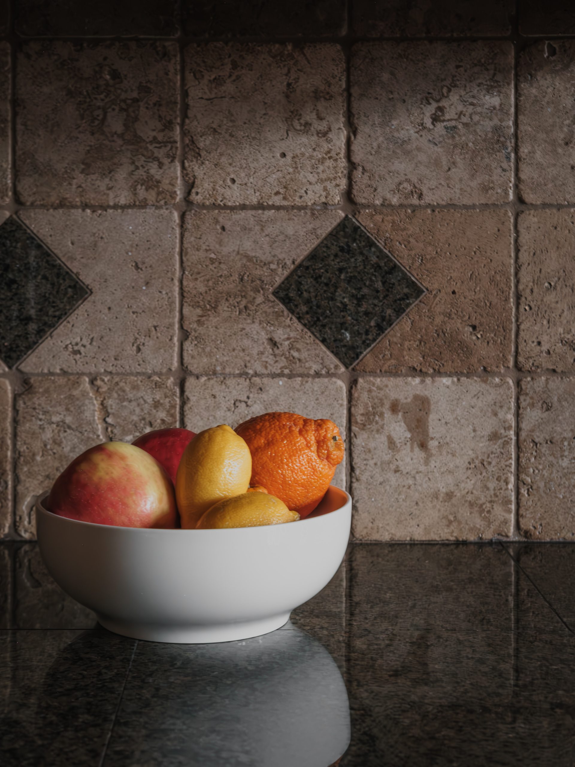 Charming rustic kitchen detail at Big Sky resort featuring stone tile backsplash and fresh fruit bowl