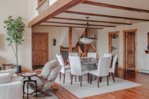 Big Sky resort home dining room with rustic chandelier, wood floors, staircase, and lodge-style architecture
