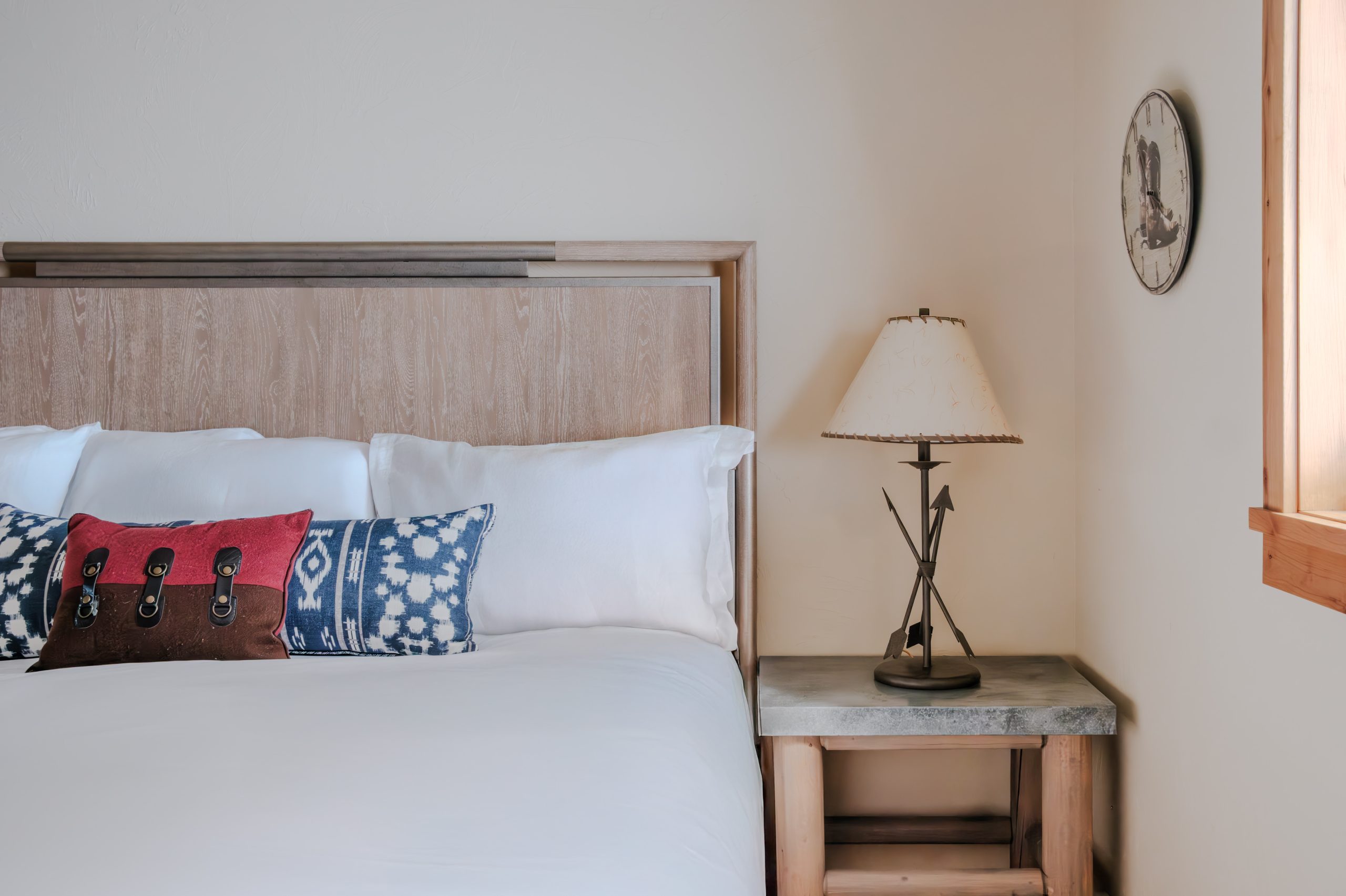 King bed in Big Sky mountain resort bedroom with western accent pillows, wood headboard, and bedside lamp