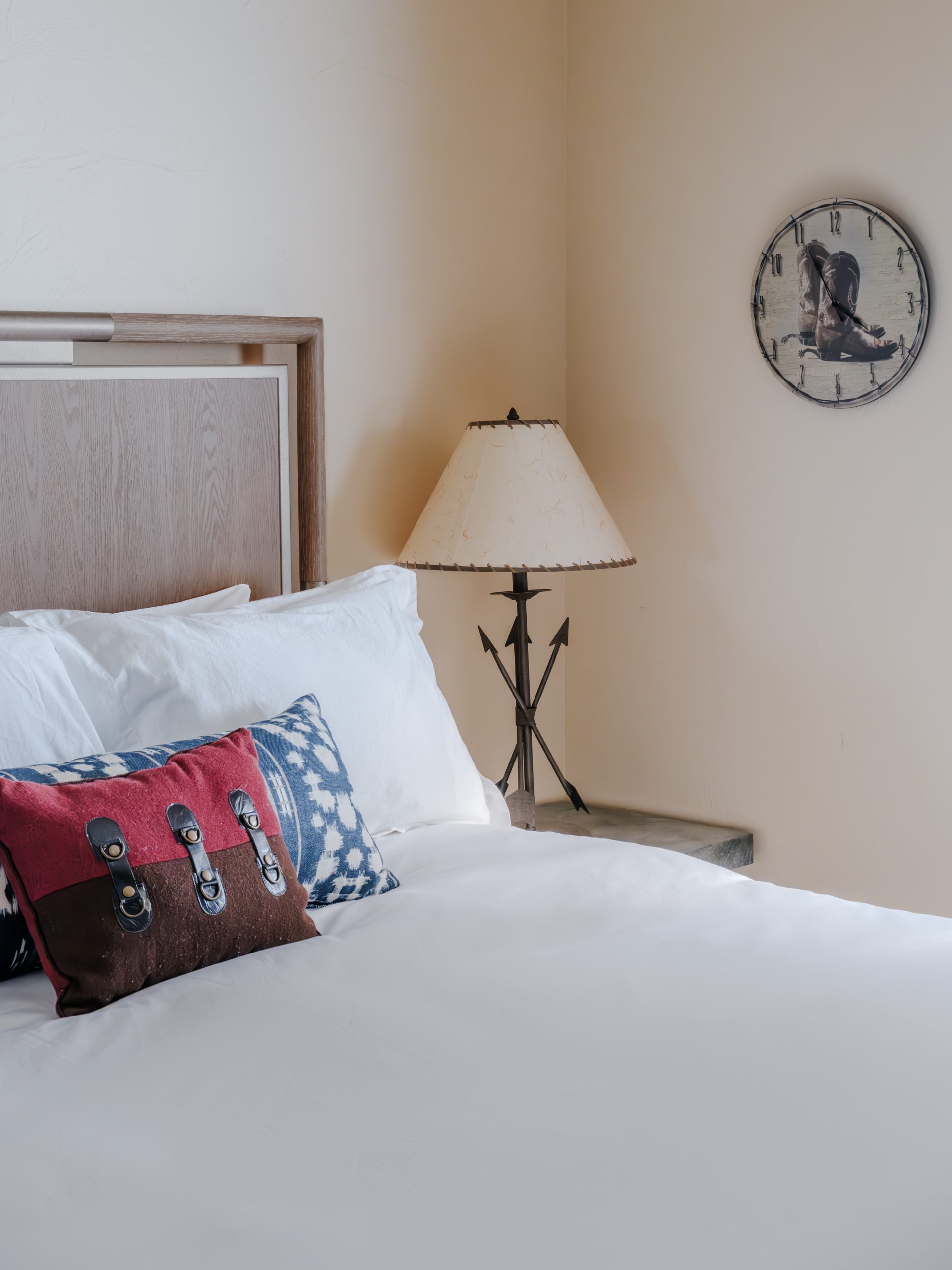 Cozy Big Sky resort bedroom featuring king bed, rustic nightstand, western lamp, and lodge-style decor