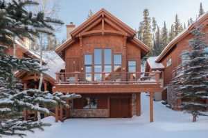 Big Sky ski resort townhome with private balcony, wood architecture, and snow-covered grounds