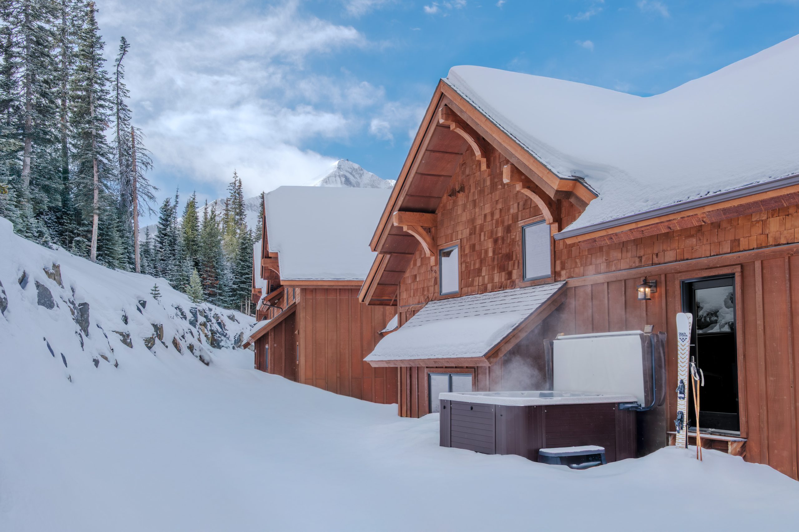 Private hot tub at Big Sky ski resort home with steam rising in snowy winter setting