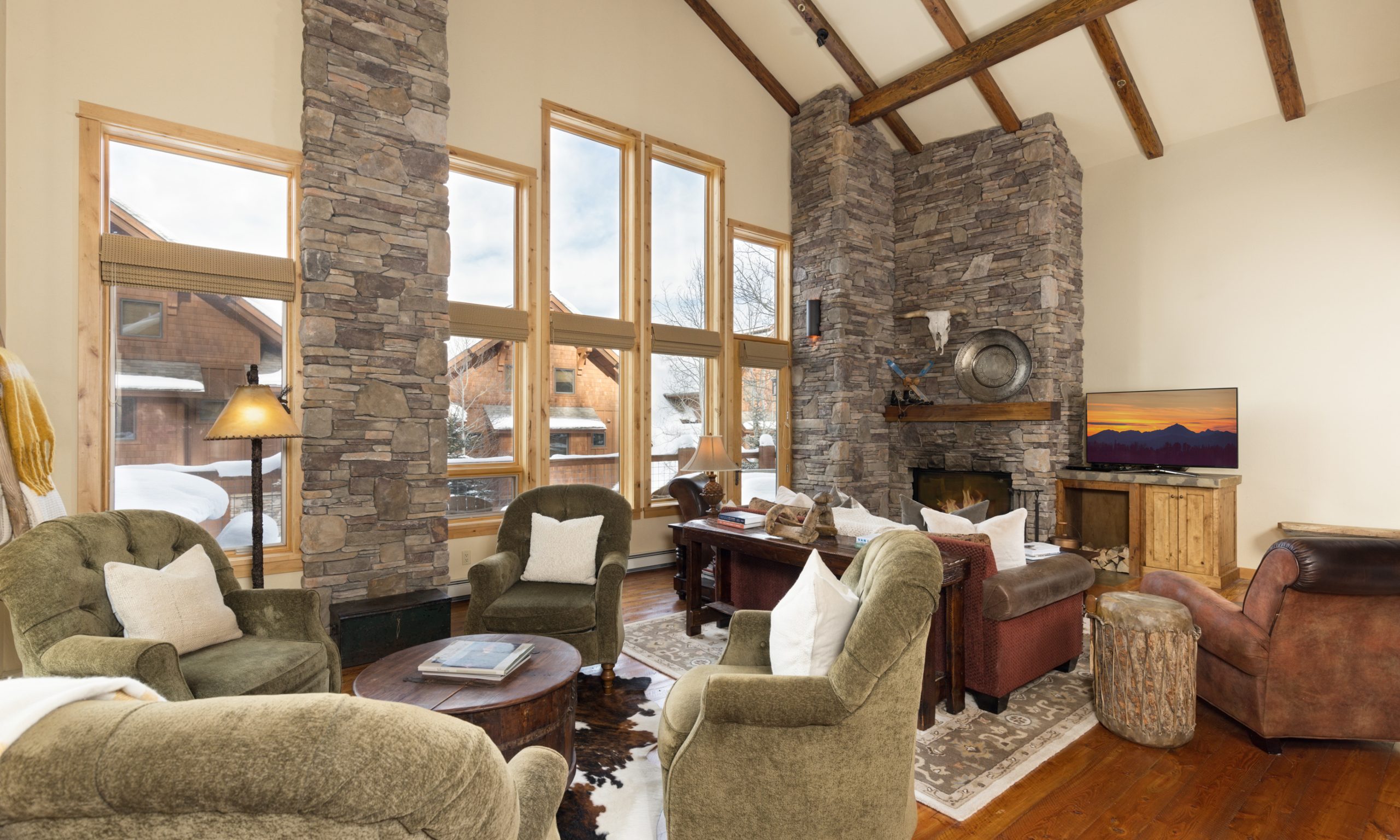 Luxury alpine living room with floor-to-ceiling windows overlooking Big Sky Resort slopes