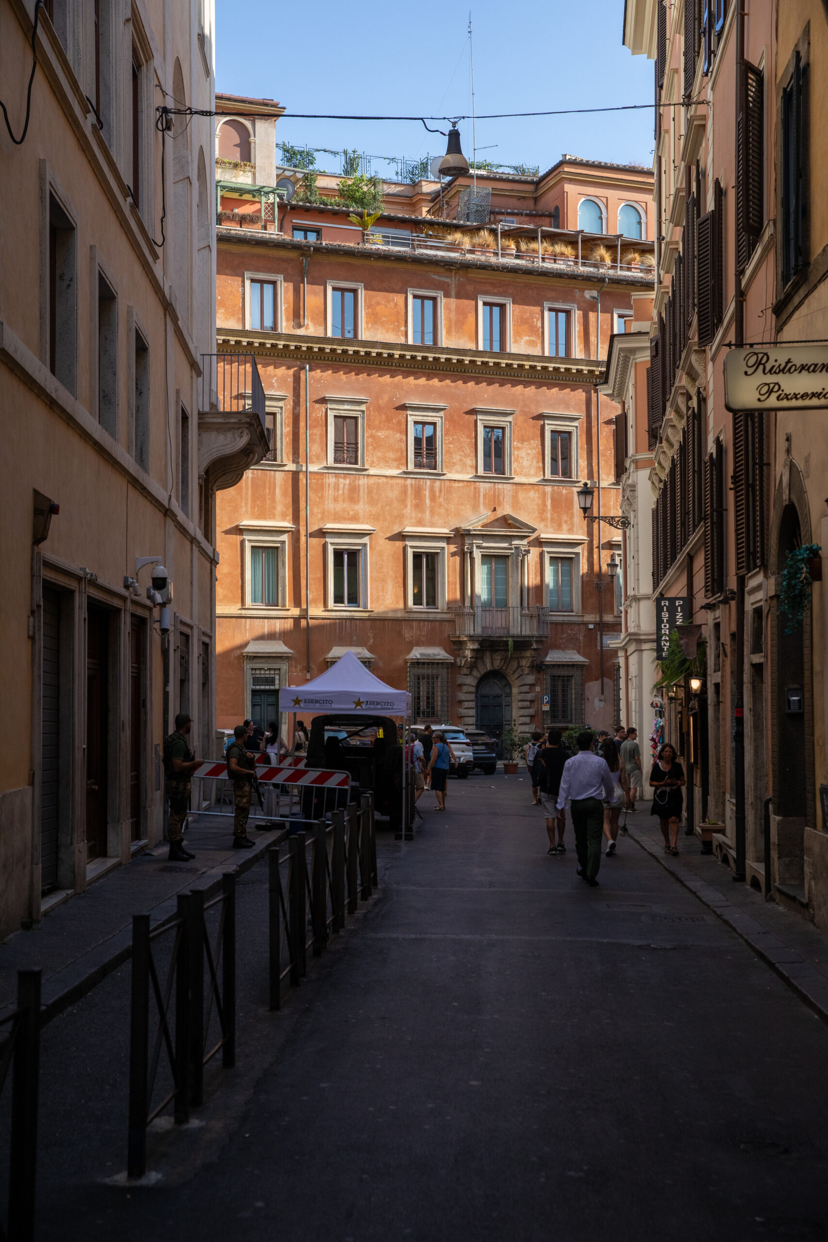 Cobblestone street lined with restaurants and historic buildings near the Spanish Steps in Rome.