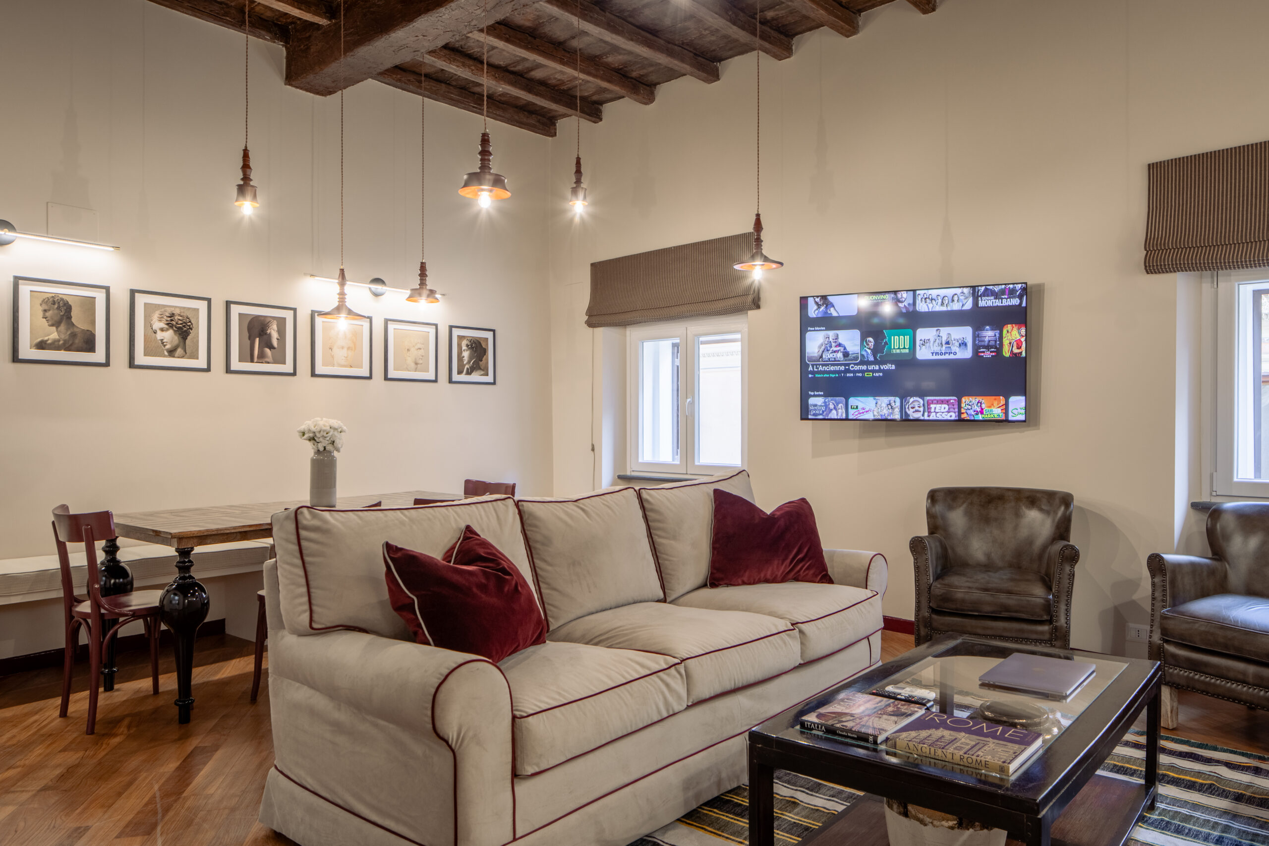 Elegant living room with classic furnishings and rich red accents in a Rome apartment by Equity Residences