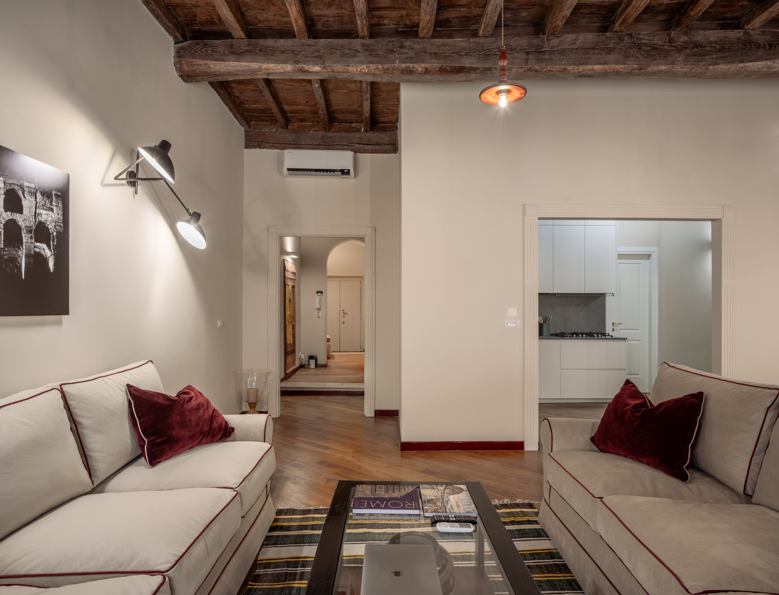 Luxury modern living room with classic furnishings and rich red accents in a Rome apartment by Equity Residences