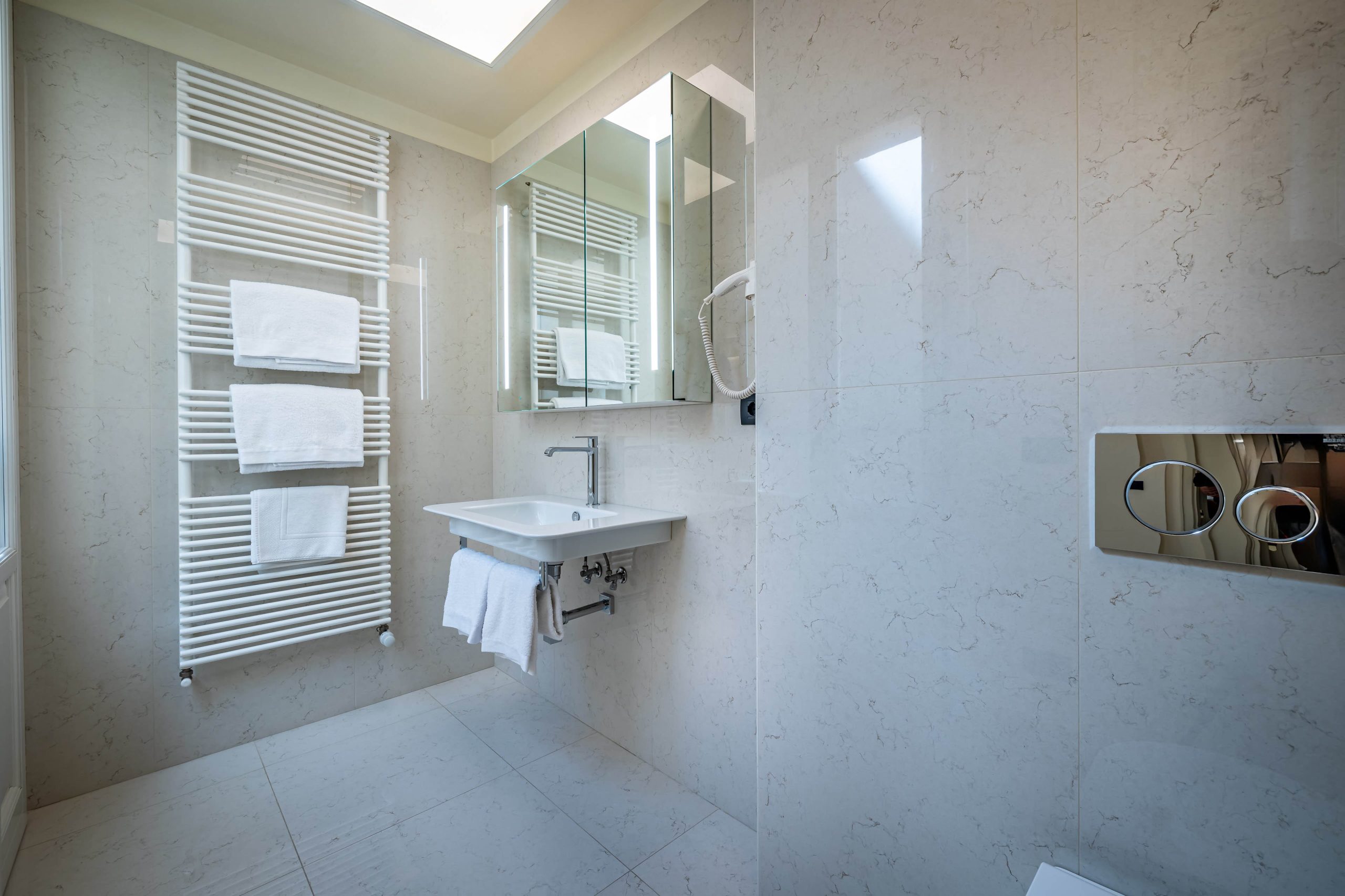 Elegant bathroom with illuminated mirror and sink in Florence luxury apartment with Duomo view